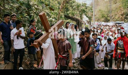 Les dévots chrétiens participent à une représentation pour la reconstitution de la crucifixion de Jésus-Christ lors d'une procession le vendredi Saint, le 29 mars 2024 à Guwahati, Assam, Inde. Le vendredi Saint est une fête chrétienne commémorant la crucifixion de Jésus-Christ et sa mort au Calvaire. Crédit : David Talukdar/Alamy Live News Banque D'Images