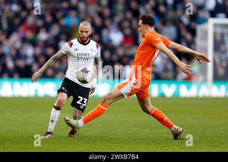 Joe Ward de Derby County (à gauche) et Kyle Joseph de Blackpool se battent pour le ballon lors du match de Sky Bet League One au Pride Park Stadium, Derby. Date de la photo : vendredi 29 mars 2024. Banque D'Images