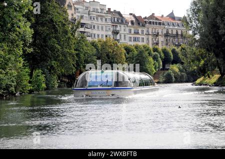 Balade en bateau sur L'ILL, Strasbourg, Alsace, bateau touristique naviguant sur une rivière avec des reflets de la ville et des arbres le long du rivage, Strasbourg Banque D'Images