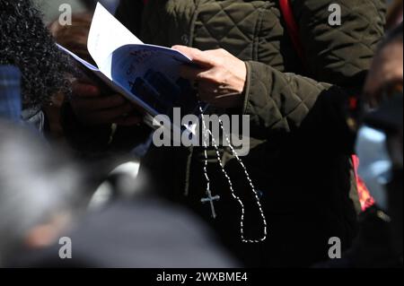 New York, États-Unis. 29 mars 2024. À l'occasion de la semaine Sainte de Pâques, un adorateur tient un chapelet tout en assistant à la marche « The Way of the Cross » de Brooklyn à Manhattan, New York, NY, le 29 mars 2024. La procession annuelle a lieu le vendredi Saint, imitant la marche du Christ vers le Calvaire. (Photo par Anthony Behar/Sipa USA) crédit : Sipa USA/Alamy Live News Banque D'Images