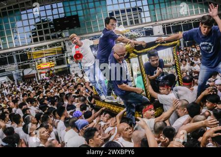 29 mars 2024, Binangonan, Rizal, Philippines : les dévots catholiques luttent pour manœuvrer le transport de Jésus mort à Binangonan, Rizal le vendredi Saint, 29 mars 2024. Le gewang-gewang, un mot tagalog qui se traduit par ''balancement'' en anglais, est une tradition du vendredi Saint où la plupart des hommes sont les participants. Cette vénérable tradition se concentre sur le transport du Santo Entierro ou l'icône morte de Jésus de sa maison particulière à une église tandis qu'à l'intérieur du chariot de cercueil en verre transporté principalement par des hommes dévoués pendant la procession qui est semblable au Traslacion du Nazaréen noir de Banque D'Images