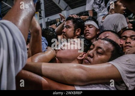 29 mars 2024, Binangonan, Rizal, Philippines : les dévots catholiques luttent pour manœuvrer le transport de Jésus mort à Binangonan, Rizal le vendredi Saint, 29 mars 2024. Le gewang-gewang, un mot tagalog qui se traduit par ''balancement'' en anglais, est une tradition du vendredi Saint où la plupart des hommes sont les participants. Cette vénérable tradition se concentre sur le transport du Santo Entierro ou l'icône morte de Jésus de sa maison particulière à une église tandis qu'à l'intérieur du chariot de cercueil en verre transporté principalement par des hommes dévoués pendant la procession qui est semblable au Traslacion du Nazaréen noir de Banque D'Images