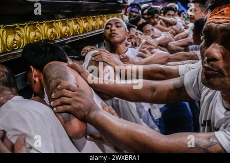 29 mars 2024, Binangonan, Rizal, Philippines : les dévots catholiques luttent pour manœuvrer le transport de Jésus mort à Binangonan, Rizal le vendredi Saint, 29 mars 2024. Le gewang-gewang, un mot tagalog qui se traduit par ''balancement'' en anglais, est une tradition du vendredi Saint où la plupart des hommes sont les participants. Cette vénérable tradition se concentre sur le transport du Santo Entierro ou l'icône morte de Jésus de sa maison particulière à une église tandis qu'à l'intérieur du chariot de cercueil en verre transporté principalement par des hommes dévoués pendant la procession qui est semblable au Traslacion du Nazaréen noir de Banque D'Images