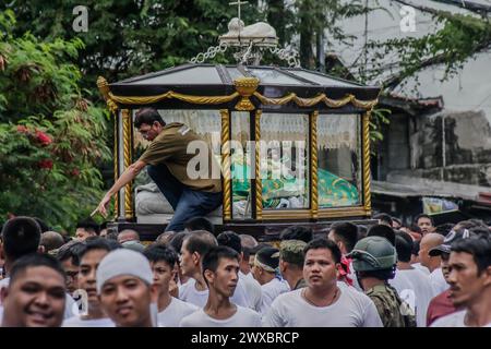 29 mars 2024, Binangonan, Rizal, Philippines : les dévots catholiques luttent pour manœuvrer le transport de Jésus mort à Binangonan, Rizal le vendredi Saint, 29 mars 2024. Le gewang-gewang, un mot tagalog qui se traduit par ''balancement'' en anglais, est une tradition du vendredi Saint où la plupart des hommes sont les participants. Cette vénérable tradition se concentre sur le transport du Santo Entierro ou l'icône morte de Jésus de sa maison particulière à une église tandis qu'à l'intérieur du chariot de cercueil en verre transporté principalement par des hommes dévoués pendant la procession qui est semblable au Traslacion du Nazaréen noir de Banque D'Images