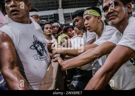 29 mars 2024, Binangonan, Rizal, Philippines : les dévots catholiques luttent pour manœuvrer le transport de Jésus mort à Binangonan, Rizal le vendredi Saint, 29 mars 2024. Le gewang-gewang, un mot tagalog qui se traduit par ''balancement'' en anglais, est une tradition du vendredi Saint où la plupart des hommes sont les participants. Cette vénérable tradition se concentre sur le transport du Santo Entierro ou l'icône morte de Jésus de sa maison particulière à une église tandis qu'à l'intérieur du chariot de cercueil en verre transporté principalement par des hommes dévoués pendant la procession qui est semblable au Traslacion du Nazaréen noir de Banque D'Images