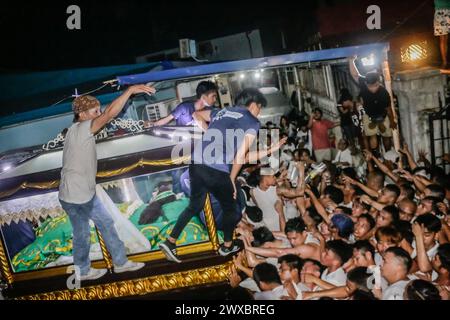 29 mars 2024, Binangonan, Rizal, Philippines : les dévots catholiques luttent pour manœuvrer le transport de Jésus mort à Binangonan, Rizal le vendredi Saint, 29 mars 2024. Le gewang-gewang, un mot tagalog qui se traduit par ''balancement'' en anglais, est une tradition du vendredi Saint où la plupart des hommes sont les participants. Cette vénérable tradition se concentre sur le transport du Santo Entierro ou l'icône morte de Jésus de sa maison particulière à une église tandis qu'à l'intérieur du chariot de cercueil en verre transporté principalement par des hommes dévoués pendant la procession qui est semblable au Traslacion du Nazaréen noir de Banque D'Images