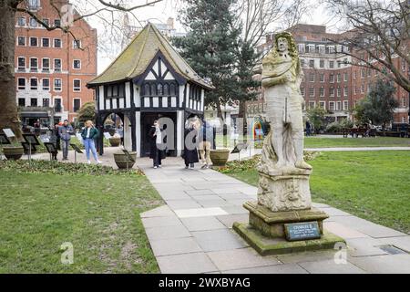 Sculpture en plein air de Charles II d'Angleterre et fausse croix de marché Tudor situé dans Soho Gardens, Soho Square, Londres. Bâtiment à ossature de bois. Banque D'Images