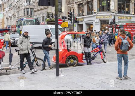 Pédicab ou pousse-pousse se stationne sur les lignes jaunes en attendant son prochain client. Le Pedicabs London Bill réglementera les tarifs et améliorera la sécurité. Banque D'Images