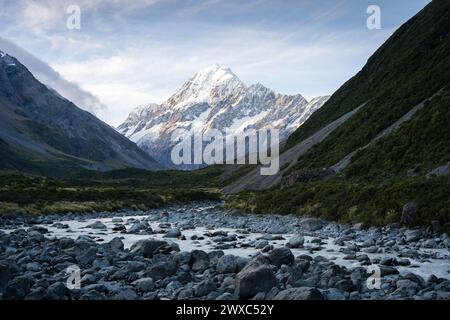 Vallée alpine avec rivière glaciaire qui coule à travers et pic proéminent en toile de fond pendant le coucher du soleil, Aoraki. Banque D'Images