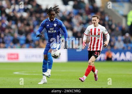 Cardiff, Royaume-Uni. 29 mars 2024. Josh Wilson-Esbrand de Cardiff City (l) en action. EFL Skybet championnat match, Cardiff City v Sunderland au Cardiff City Stadium de Cardiff, pays de Galles, le vendredi Saint 29 mars 2024. Cette image ne peut être utilisée qu'à des fins éditoriales. Usage éditorial exclusif, photo par Andrew Orchard/Andrew Orchard photographie sportive/Alamy Live News crédit : Andrew Orchard photographie sportive/Alamy Live News Banque D'Images