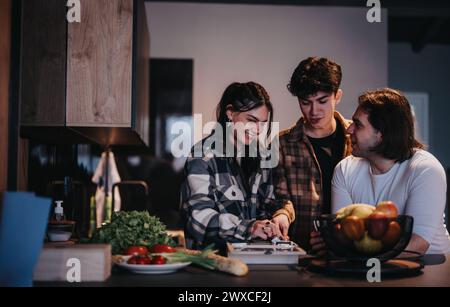 Amis occasionnels se réunissant à la maison, profitant du temps ensemble dans la cuisine Banque D'Images