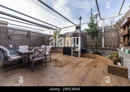 une terrasse remplie de plantes avec des meubles en métal lisse et des séparateurs en osier pour l'intimité avec des escaliers avec des balustrades en fer forgé peint en noir stonewar Banque D'Images