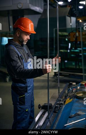 L'homme dans un casque de sécurité travaille avec une entretoise Banque D'Images