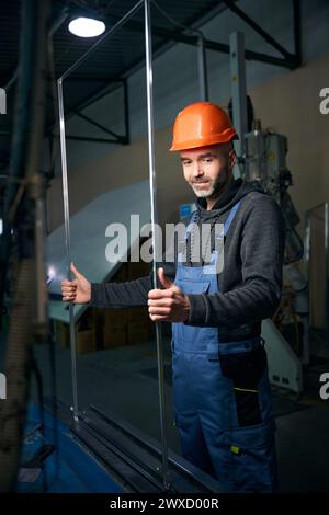 Master travaille avec un cadre espaceur dans une production de fenêtres Banque D'Images