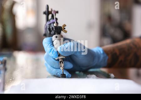 Mexico, Mexique. 28 mars 2024. À Mexico, Mexique, le 28 mars 2024, le tatoueur Israel Ortega, également connu sous le nom de Mr. Kaliman, utilise une machine à tatouer dans un salon du quartier d'Iztapalapa. Fort de plus de 18 ans d’expérience, il mélange les styles traditionnels américain, japonais et tribal dans son tatouage généreux (Photo de Luis Marin/Eyepix Group) crédit : NurPhoto SRL/Alamy Live News Banque D'Images