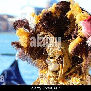 Venise, VE, Italie - 13 février 2024 : masque au Carnaval de Venise avec très grande coiffe à plumes Banque D'Images