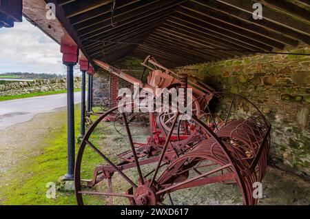 Castleward, County Down, Irlande du Nord 15 mars 2024 - vieilles machines agricoles rouillées dans une grange ouverte Banque D'Images