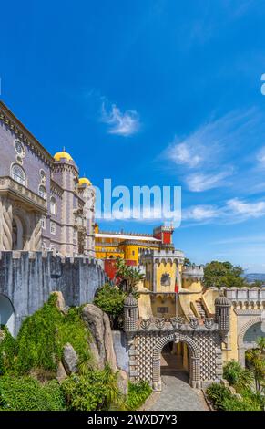 Extérieur et vue large du Palais de Pena de couleurs jaune, rouge et mosaïque avec le chemin jusqu'à l'entrée voûtée avec bas-reliefs du Palais, und Banque D'Images