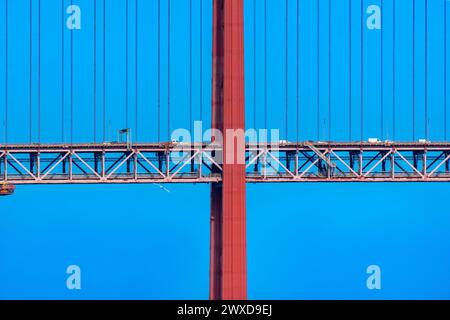 Détail frontal d'une partie du pont suspendu 25 de Abril avec des câbles en acier rouge soutenant la structure avec des voitures et des camionnettes roulant dessus pour y accéder Banque D'Images