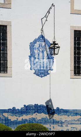 Panneau de carreaux de céramique bleus sur un mur blanc de Santa Luzia de Viuva Lamego dans le quartier Miradors d'Alfama, Portugal, avec un forgé suspendu Banque D'Images