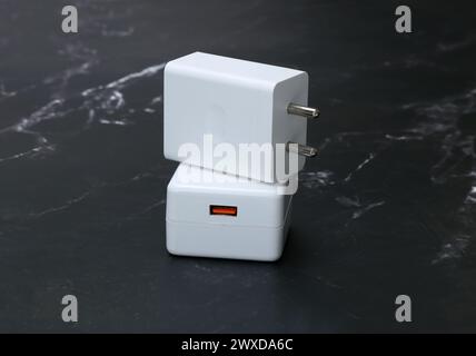 chargeurs de smartphone blancs sur le fond en marbre noir Banque D'Images