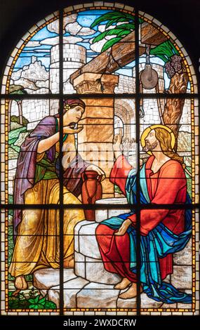 MILAN, ITALIE - 6 MARS 2024 : Jésus et la Samaritaine dans le vitrail de l'église Chiesa del Redentore par un artiste inconnu (1933). Banque D'Images