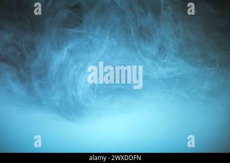 nuages de fumée bleue sur fond noir, nuages de peinture dans l'eau, aquarium, fond abstrait, texture Banque D'Images