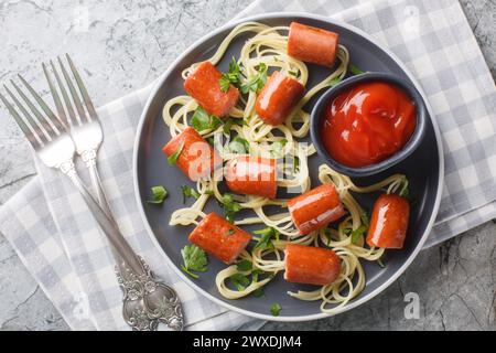 Araignées alimentaires d'Halloween spaghetti drôles avec hot dog et ketchup gros plan dans une assiette sur la table. Vue horizontale de dessus Banque D'Images