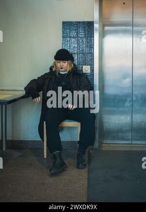 Jeune modèle féminin audacieux avec maquillage foncé, lèvres foncées, cheveux blonds et vêtements foncés Banque D'Images