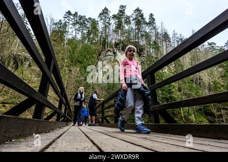 Hrensko, République tchèque. 29 mars 2024. Randonneurs traversant le pont Mezni mustek sur le site des brûlés après le grand incendie de 2022 dans le parc national de la Suisse tchèque, district de Decin, région d'Usti nad Labem, République tchèque, le 29 mars 2024. Crédit : Ondrej Hajek/CTK photo/Alamy Live News Banque D'Images