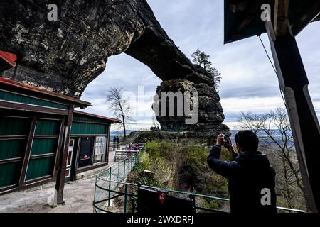 Hrensko, République tchèque. 29 mars 2024. Un touriste photographie la porte de Pravcicka dans le site des brûlures après le grand incendie de 2022 dans le parc national de la Suisse tchèque, district de Decin, région d'Usti nad Labem, République tchèque, le 29 mars 2024. Crédit : Ondrej Hajek/CTK photo/Alamy Live News Banque D'Images