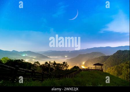 Symphonie du ciel printanier : le charmant croissant de lune est suspendu dans le ciel. Tôt le matin, vue sur les jardins de thé, la mer de ​​clouds et le lever du soleil, Temple Nanshan. Banque D'Images