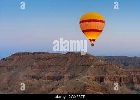 Un tour en montgolfière au lever du soleil au-dessus de la Vallée des Rois, Louxor, Égypte. Banque D'Images