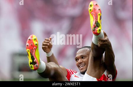 Leipzig, Allemagne. 30 mars 2024. Football, Bundesliga, RB Leipzig - FSV Mainz 05, Journée 27, Red Bull Arena. Lois Openda de Leipzig réagit après son action. Crédit : Hendrik Schmidt/dpa - REMARQUE IMPORTANTE: conformément aux règlements de la DFL German Football League et de la DFB German Football Association, il est interdit d'utiliser ou de faire utiliser des photographies prises dans le stade et/ou du match sous forme d'images séquentielles et/ou de séries de photos de type vidéo./dpa/Alamy Live News Banque D'Images