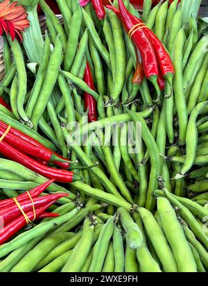 Gros plan de haricots verts et de grappes de piments rouges sur un marché en plein air à Izmir, en Turquie Banque D'Images