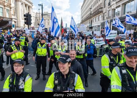 The Strand, Londres, Royaume-Uni. 30 mars 2024. Une manifestation est en cours contre l'escalade de l'action militaire à Gaza alors que le conflit entre Israël et le Hamas se poursuit. Organisés par des groupes tels que Palestine Solidarity Campaign et Stop the War Coalition, intitulés « manifestation nationale » et avec des appels à « Halte au génocide », « cessez-le-feu maintenant » et « Libérez la Palestine », les manifestants sont partis de Russell Square avant de se diriger vers Trafalgar Square. Ils ont franchi une contre-manifestation israélienne au large du Strand, derrière un cordon policier Banque D'Images