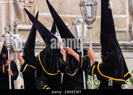 Antigua, Guatemala. 29 mars 2024. Une confrérie de pénitents, portant des chapeaux de capirote, attend devant l'église Escuela de Cristo le début de la procession du vendredi Saint Senor Sepultado pendant Semana Santa, le 29 mars 2024 à Antigua, Guatemala. La procession opulente est l'une des plus grandes au monde impliquant des milliers de dévots et dure 12 heures. Crédit : Richard Ellis/Richard Ellis/Alamy Live News Banque D'Images