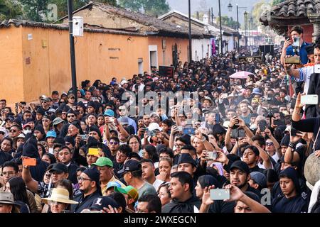 Antigua, Guatemala. 29 mars 2024. Des milliers de personnes se rassemblent pour regarder le flotteur processionnel massif de Senor Sepultado transporté à travers le centre historique de la ville au début de la procession du vendredi Saint pendant Semana Santa, le 29 mars 2024 à Antigua, Guatemala. La procession opulente est l'une des plus grandes au monde nécessitant plus de 100 personnes pour porter le flotteur qui prend 12 heures pour compléter la procession. Crédit : Richard Ellis/Richard Ellis/Alamy Live News Banque D'Images