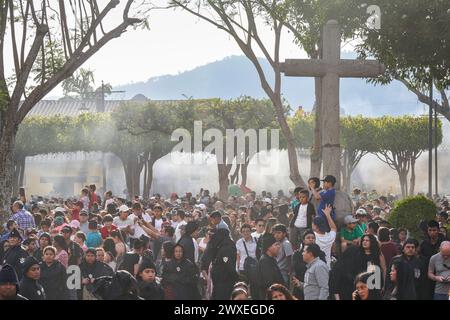 Antigua, Guatemala. 29 mars 2024. Baigné d'encens, des milliers de personnes regardent le flotteur processionnel massif Senor Sepultado transporté à travers le centre historique de la ville au début de la procession du vendredi Saint pendant Semana Santa, le 29 mars 2024 à Antigua, Guatemala. La procession opulente est l'une des plus grandes au monde nécessitant plus de 100 personnes pour porter le flotteur qui prend 12 heures pour compléter la procession. Crédit : Richard Ellis/Richard Ellis/Alamy Live News Banque D'Images