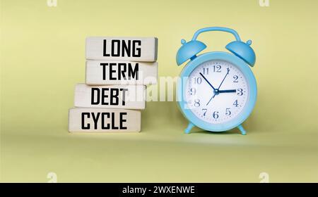 Symbole du cycle de la dette à long terme. Cycle de dette à long terme sur blocs de bois. Banque D'Images