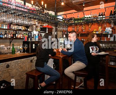 Clients assis à une petite table par bar dans le restaurant bar populaire, Cervecería la Tasca, Grenade, Espagne Banque D'Images