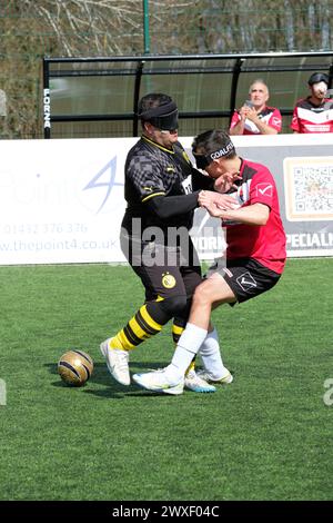 Royal National College for the Blind, Hereford, Royaume-Uni – samedi 30 mars 2024 – Round 3 de la European Blind Football League ( EBFL ) qui s'est tenu au Royal National College for the Blind à Hereford avec six équipes européennes. Les joueurs du Borussia Dortmund BVB ( maillot noir ) et Pirsos Thessalonique de Grèce ( maillot rouge ) se heurtent alors qu'ils suivent le hochet du ballon. Photo Steven May / Alamy Live News Banque D'Images