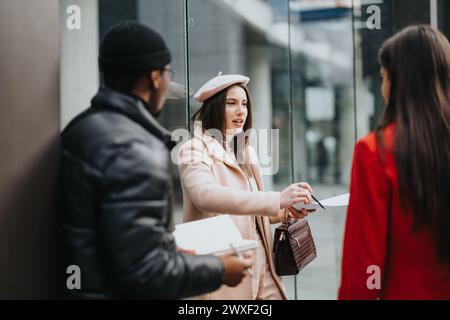 Groupe diversifié d'amis échangeant des documents dans la rue urbaine Banque D'Images