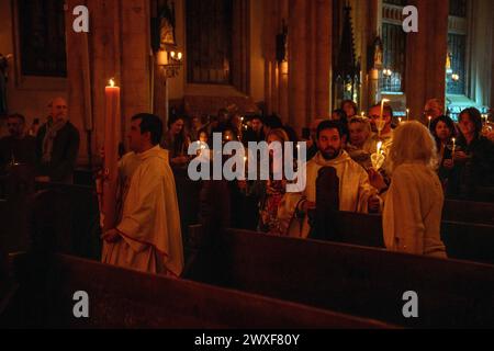 30 mars 2024, Beyoglu, Istanbul, Turquie : une femme, vient à la bougie de Pâques allumée par le prêtre après être entré dans l'Église et allume sa propre bougie. Le samedi Saint, le rite de lumière a eu lieu au préparé L'église Antony de Padoue, connue localement sous le nom d'sent Antuan, est la plus grande église catholique d'Istanbul. Le rituel commence par le « service de la lumière ». Le prêtre, vêtu de sa robe blanche, vient devant le feu qui brûle devant l'église avec une bougie de pâques et allume la bougie de pâques. La première bougie allumée est considérée comme le symbole du Christ Jésus cette année. Crédit : ZUMA Press, in Banque D'Images