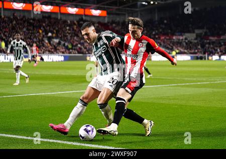 Diogo Dalot de Manchester United (à gauche) et Mathias Jensen de Brentford s'affrontent pour le ballon lors du match de premier League au Gtech Community Stadium de Londres. Date de la photo : samedi 30 mars 2024. Banque D'Images