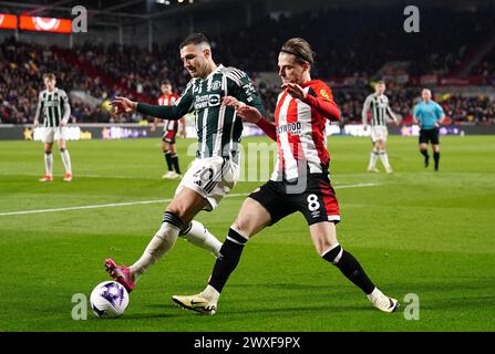 Diogo Dalot de Manchester United (à gauche) et Mathias Jensen de Brentford s'affrontent pour le ballon lors du match de premier League au Gtech Community Stadium de Londres. Date de la photo : samedi 30 mars 2024. Banque D'Images