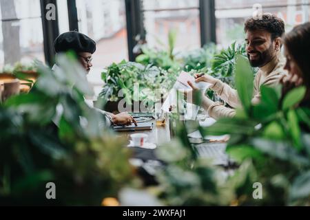 Équipe multiraciale de partenaires commerciaux engagés dans une discussion animée dans un espace de travail intérieur lumineux. Banque D'Images