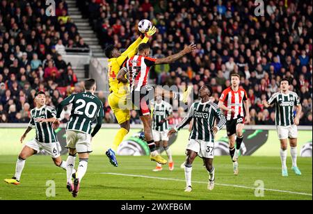 Le gardien de Manchester United Andre Onana et Ivan Toney de Brentford sautent pour le ballon lors du match de premier League au Gtech Community Stadium de Londres. Date de la photo : samedi 30 mars 2024. Banque D'Images