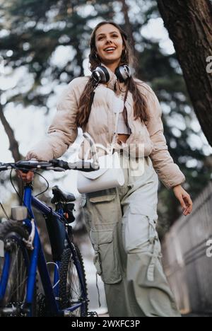 Jeune femme active profitant d'une journée avec son vélo et ses écouteurs. Banque D'Images