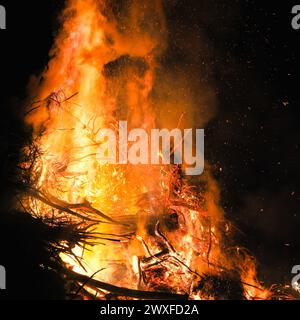 Sythen, NRW, Allemagne. 30 mars 2024. Les habitants et les visiteurs se rassemblent pour le feu de joie annuel de Pâques à la ferme Prickingshof à Sythen, Westfalie (Münsterland). L'allumage des feux de joie de Pâques est une tradition depuis de nombreux siècles en Allemagne, généralement le samedi Saint ou le dimanche de Pâques. Les services d’incendie et d’urgence veillent à ce que le feu soit protégé pendant que les bénévoles ont soigneusement inspecté le bois de chauffage pour s’assurer qu’aucune faune ne s’est réfugiée dans les branches. Crédit : Imageplotter/Alamy Live News Banque D'Images